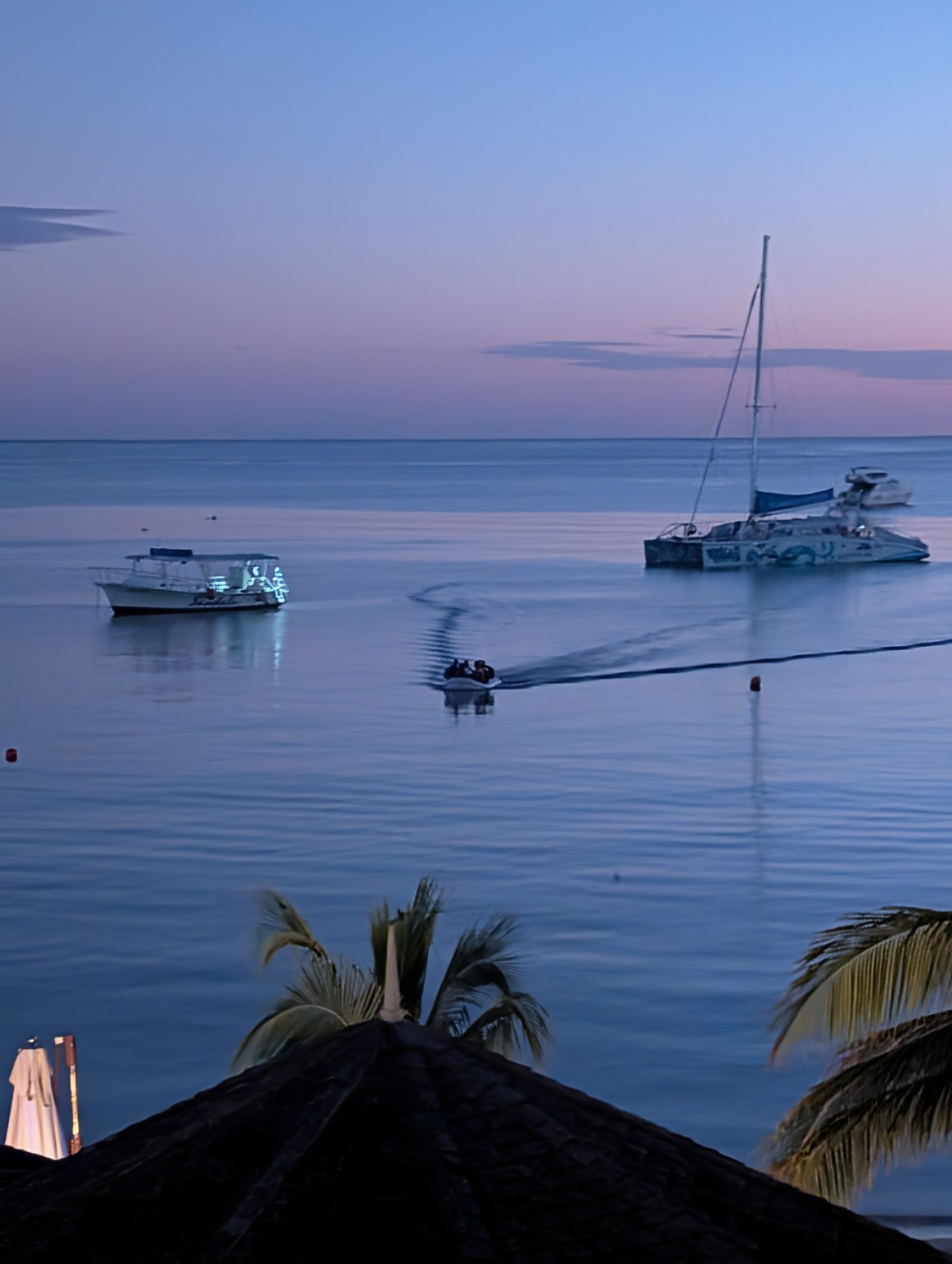 Boats resting on calm blue water at twilight